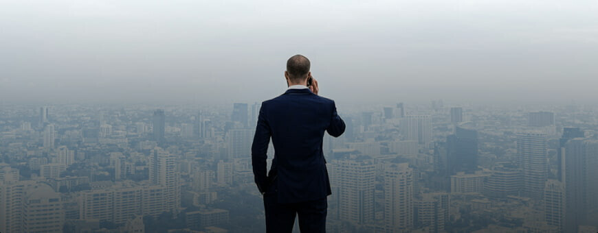 A man with a cellphone looking at the big city