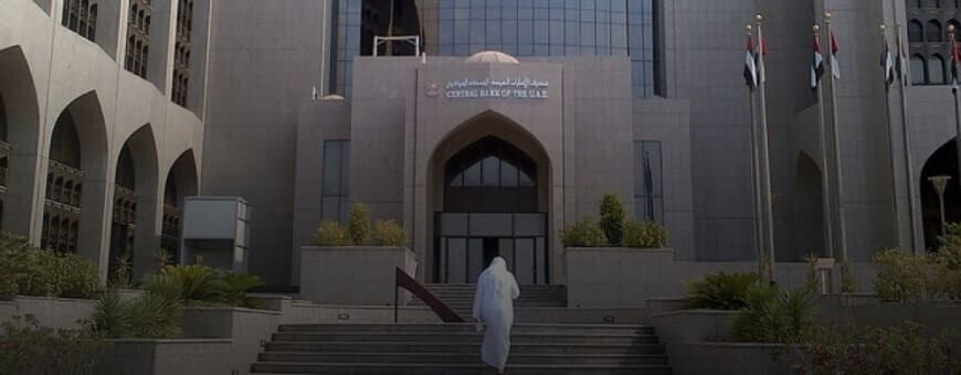 A male individual walking into the Central Bank of the UAE.