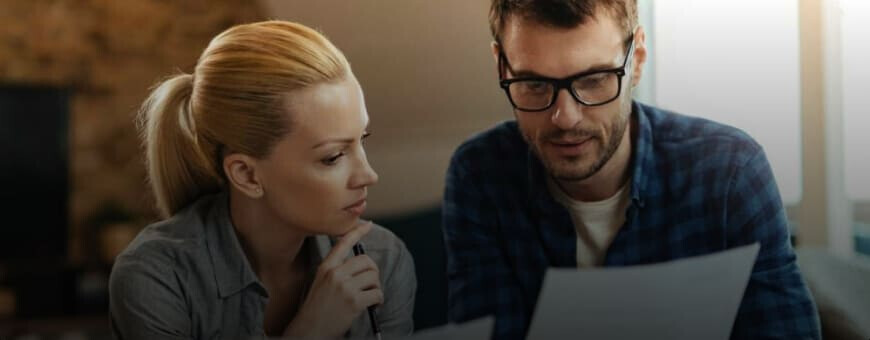 A man and a woman looking at a UAE mortgage document