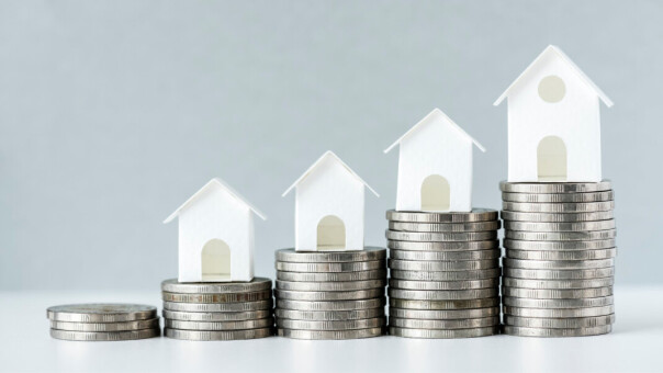 Houses on top of five piles of coins that progressively grow in size